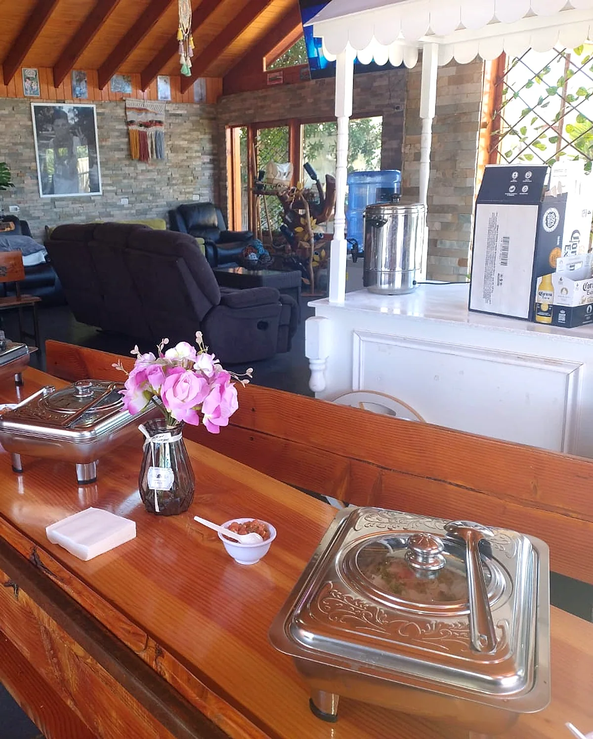 Buffet con chafing dishes y flores, atendido en el evento